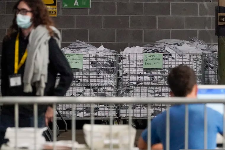 Bins of the empty envelopes from ballots are stored along a wall as election office workers process ballots while counting continues from the general election at the Allegheny County elections returns warehouse in Pittsburgh, Friday, Nov. 6, 2020.