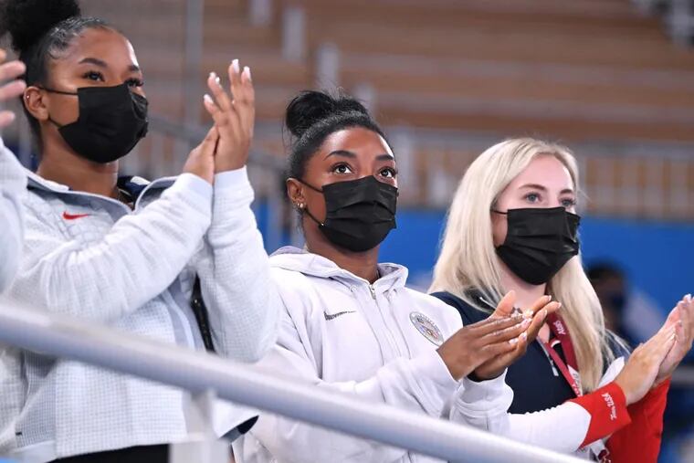 Simone Biles, center, has cheered her teammates on from the stands for the last few days. She'll be back in action on Tuesday.