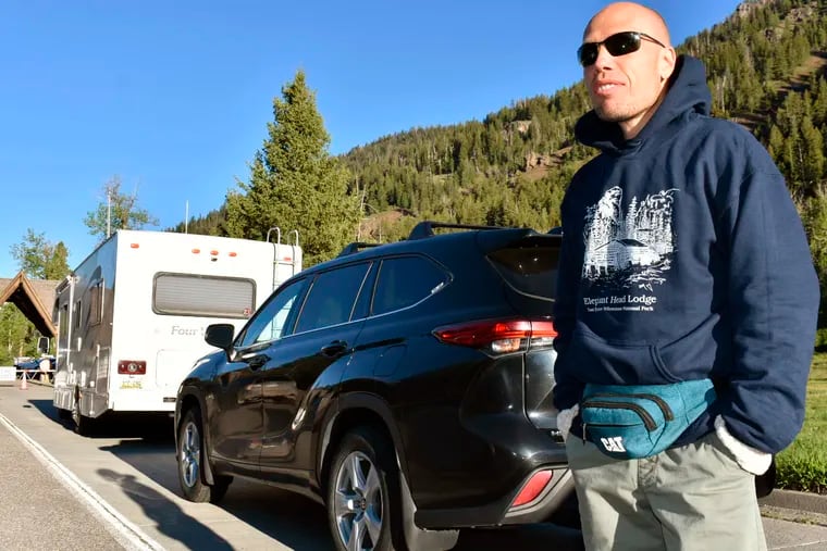 Muris Demirovic waits by his rental car outside Yellowstone National Park for the entrance gate to open on Wednesday.