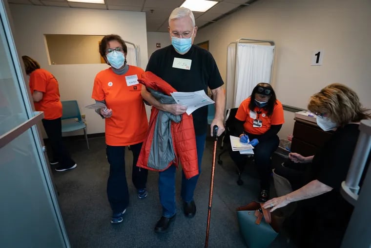 Registered nurse Karen Leyser, left, assist Frank Bason to the waiting area after he received the Pfizer vaccine at Suburban Community Hospital which administered the COVID-19 vaccine to Montgomery County residents, Feb. 10th, 2021. This is Suburban's first COVID-19 vaccine clinic for members of the public who meet the 1A criteria.