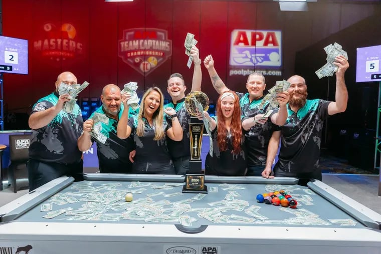 Members of the South Jersey team "You're Not My Real Mom," who won first place for 8-Ball in the 2024 American Poolplayers Association World Pool Championships in Las Vegas, play around with some of their $30,000 in prize money. From left to right: Bryant Passarella, Travis Freeman, team captain Brianna Aristeo, Brad Silver, Brittany Connelly, Anthony Zubec, and Jonathan Loteck.