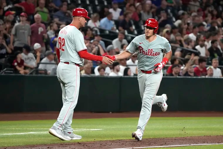 The Phillies' J.T. Realmuto, right, celebrates with third base coach Dusty Wathan after hitting a solo home run against the Diamondbacks on Thursday.