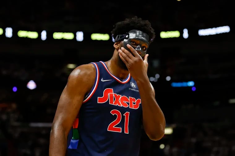 Sixers center Joel Embiid adjusts his mask after returning to the game against the Miami Heat during the second quarter  of Game 5.