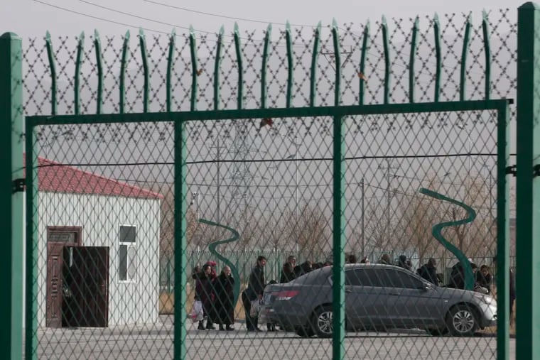 In this 2018, file photo, people line up at the Artux City Vocational Skills Education Training Service Center at the Kunshan Industrial Park in Artux in western China's Xinjiang region. The Associated Press found that the Chinese government was carrying out a birth control program aimed at Uighurs, Kazakhs and other largely Muslim minorities in Xinjiang.