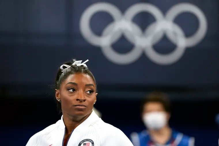 FILE - In this July 27, 2021 file photo, Simone Biles, of the United States, watches gymnasts perform after she exited the team final at the 2020 Summer Olympics, in Tokyo. Biles, who redefined excellence in gymnastics and picked up seven Olympic medals along the way, drew attention and, from some, criticism by pulling out of events in Tokyo because of a mental block that made her afraid to attempt certain dangerous moves. (AP Photo/Ashley Landis, File)