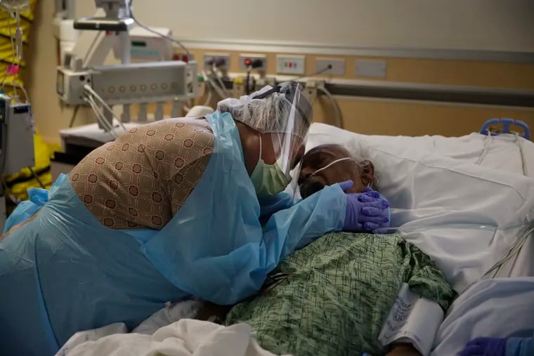 Romelia Navarro, 64, weeps while hugging her husband, Antonio, in his final moments in a COVID-19 unit at St. Jude Medical Center in Fullerton, Calif., Friday, July 31, 2020.