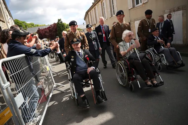 A spectator shakes the hand of a British veteran who is part of a procession leaving the Bayeux Cathedral after a ceremony to mark the 75th anniversary of D-Day in Bayeux, Normandy, France, on Thursday.