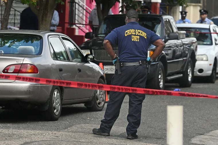 A crack in the rear windshield and the closed passenger side window of the gold Toyota Corolla Eddie Irizarry was driving are visible as police investigators are on the scene in the 100 block of East Willard Street on Aug. 14. Contrary to initial statements by the police, Commissioner Danielle Outlaw later said Irizarry was in his car when he was fatally shot.