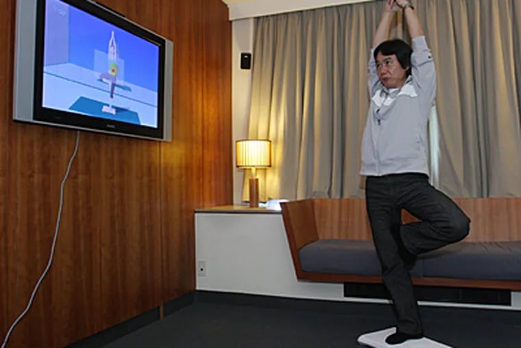 Nintendo game designer Shigeru Miyamoto, creator of Wii Fit, does a yoga pose as he demonstrates the game. (AP)