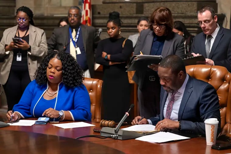 Philadelphia City Council President Kenyatta Johnson (right) and Majority Leader Katherine Gilmore Richardson go over bills and resolutions in January. Gilmore Richardson authored a bill that would change the city's contracting processes.