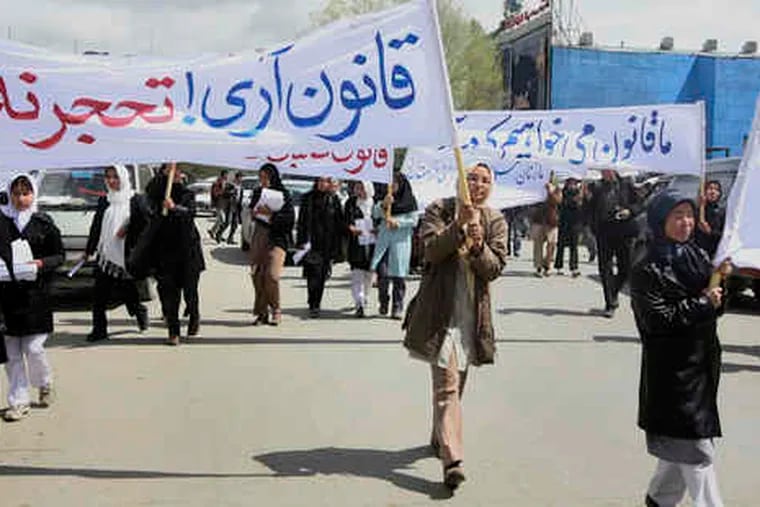 Demonstrators, mostly young women, marched in Kabul yesterday against a conservative law, signed last month, that they say legalizes marital rape. They were met with a larger protest.