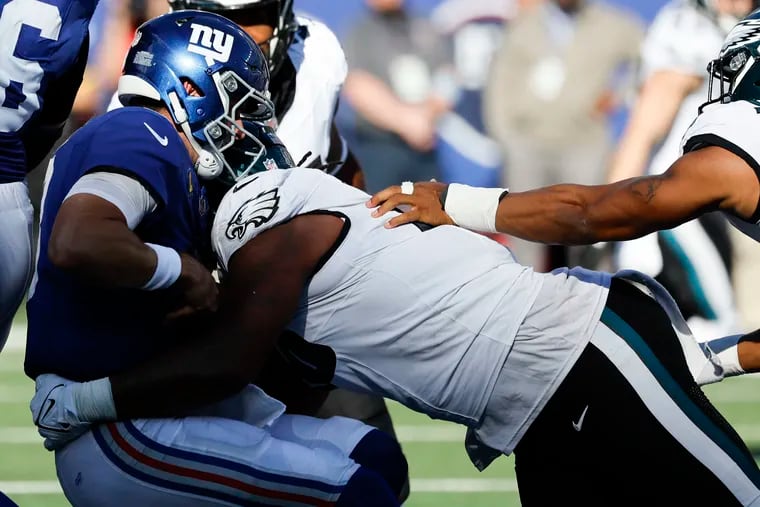 Defensive tackle Jalen Carter sacks New York Giants quarterback Daniel Jones, one of eight sacks by the Eagles defense.