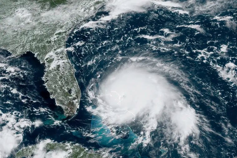 This GOES-16 satellite image taken on Sunday, Sept. 1 and provided the by National Oceanic and Atmospheric Administration (NOAA), shows Hurricane Dorian, right, churning over the Atlantic Ocean.