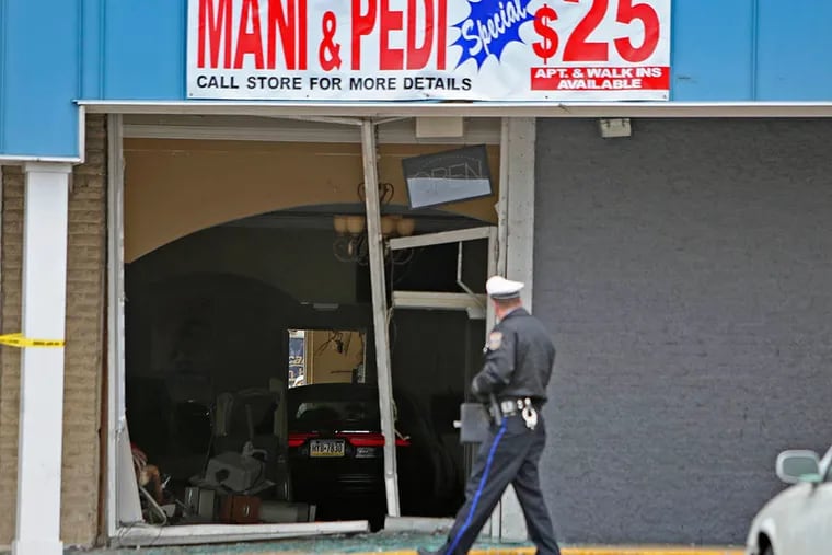 Police and L&I officials gather outside Cindy's Nail Salon on Mar. 31, 2015, in the Bustleton section of Philadelphia after a motorist drove into the shop. ( Joseph Kaczmarek / The Daily News and Inquirer )