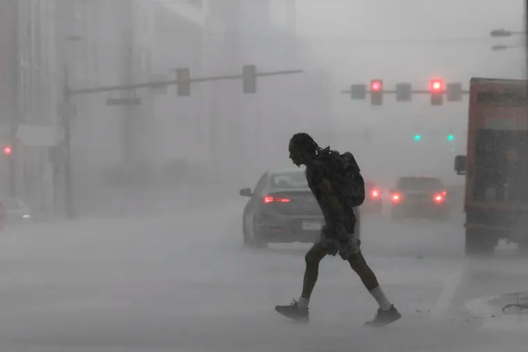 A pedestrian crosses Washington Avenue near 22nd Street during a recent downpour.