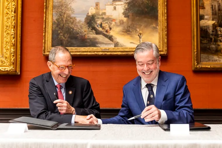 Salus University president Michael Mittelman and Drexel University president John Fry shake hands after signing documents for the merger at the Anthony J. Drexel Picture Gallery on June 13, 2023.