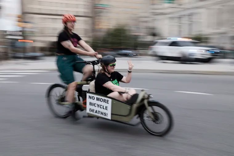 People carried messages, during a protest on wheels, as they biked from the Art Museum to City Hall to protest what they see as a lack of commitment to traffic safety from the Mayor. 