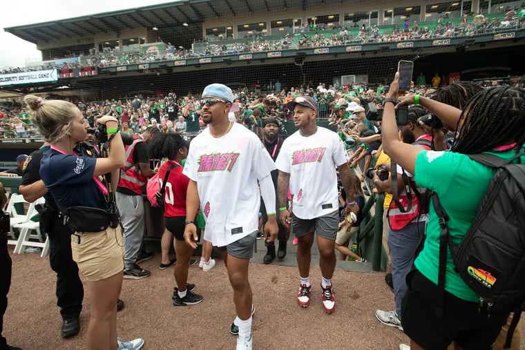 Jalen Hurts, left, and Shaun Bradley enter the field for DeVonta Smith's celebrity softball game and home run derby at Coca-Cola Park in Allentown on Saturday.