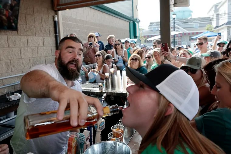 Eagles center Jason Kelce pours a fireball for Abby Davidson of Kennett Square while working the Patty’s Green bar at O'Donnell's Pour House in Sea Isle City, N.J., on Wednesday.