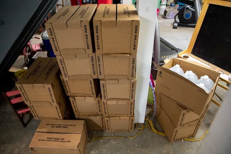 At the Cutaiar family home in Sellersville, Pa., Jodi Cutaiar, her husband, and their two daughters store cases of water jugs in the basement, seen on Wednesday, July 10, 2019. They receive five cases of water every two weeks and goes through about four cases a week.