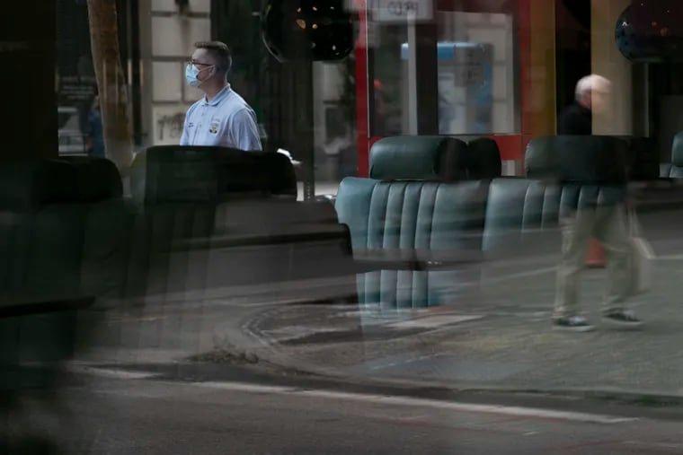 Pedestrians are seen through the glass of an empty Continental Mid-town at 18th and Chestnut Streets in Center City.