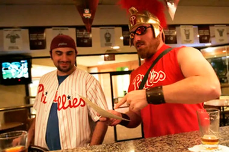 Nick Panunto and Lew Indellini (right) of New Castle, Del., join Philadelphia transplants and other fans at the Doubletree hotel sports bar in Tampa, Fla.