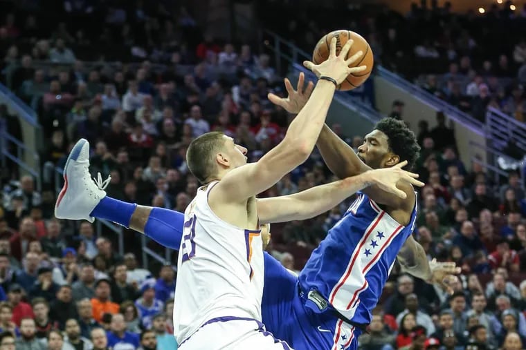 Sixers’ center Joel Embiid fights Suns’ center Alex Len for a rebound in the Sixers’ loss to the Suns on Monday.