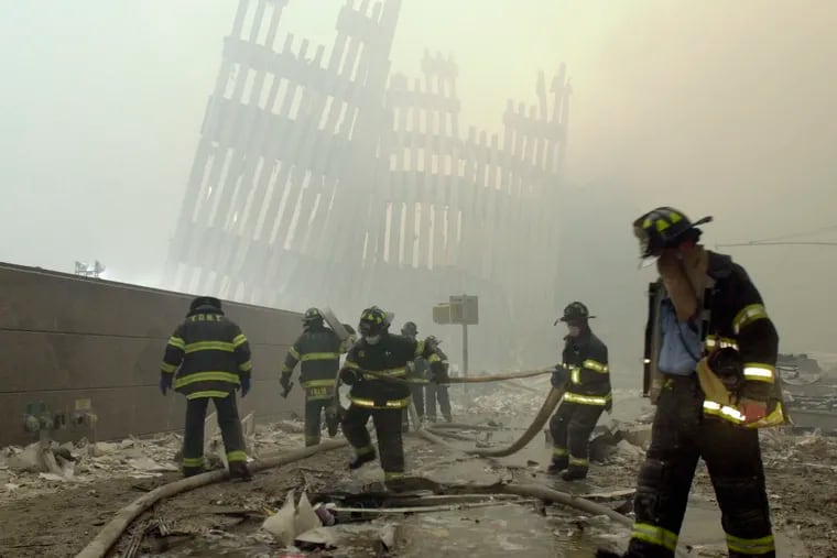 Firefighters work beneath the destroyed mullions, the vertical struts that once faced the soaring outer walls of the World Trade Center towers, after a terrorist attack in New York on Sept. 11, 2001.