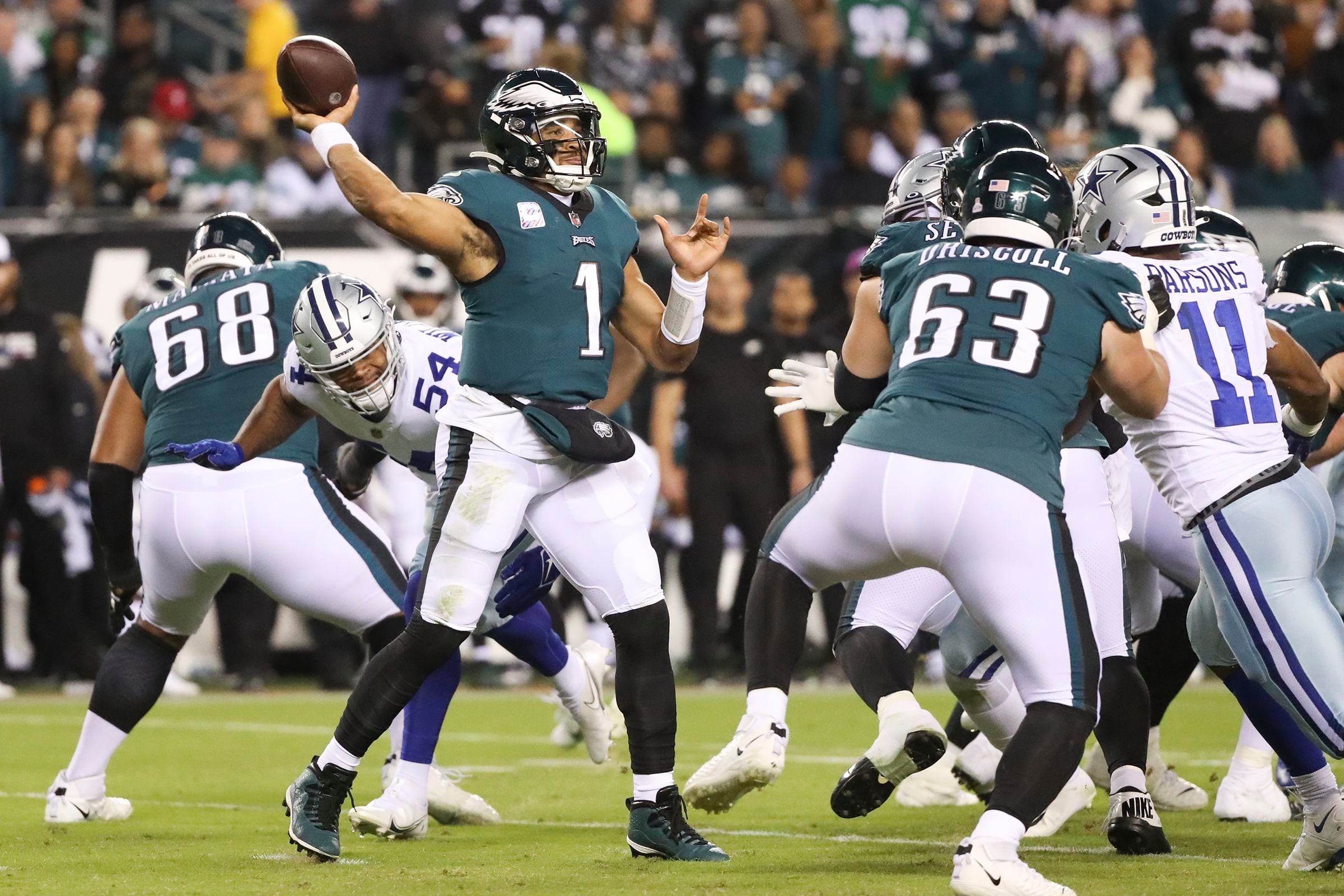 Dallas Cowboys linebacker Micah Parsons (11), middle linebacker Jaylon  Smith (9) and defensive tackle Osa Odighizuwa (97) combine to tackle  Philadelphia Eagles quarterback Jalen Hurts (1) during an NFL football  game, Monday