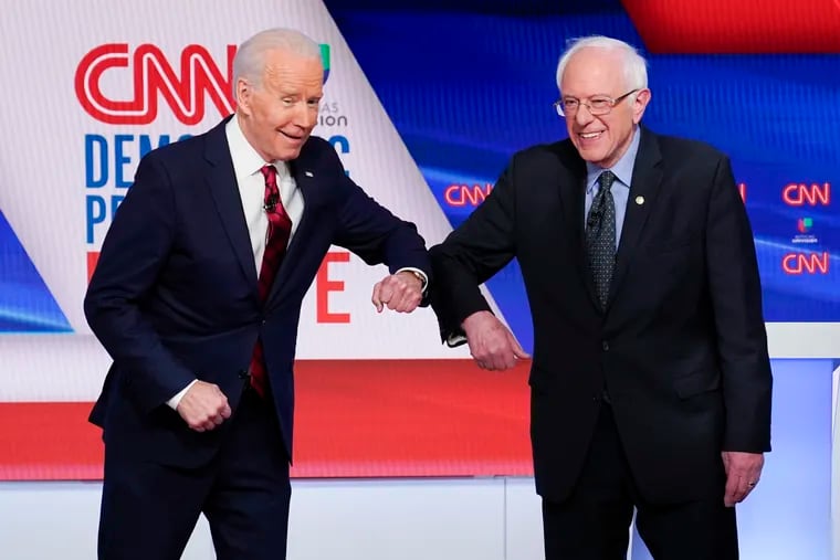 Joe Biden (left) and Sen. Bernie Sanders (I-Vt.) greet each other before Sunday's debate.