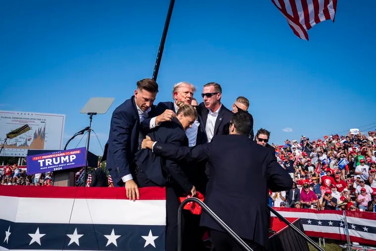 U.S. Secret Service agents remove former president Donald Trump from the stage during a campaign rally in Butler, Pa. on July 13.