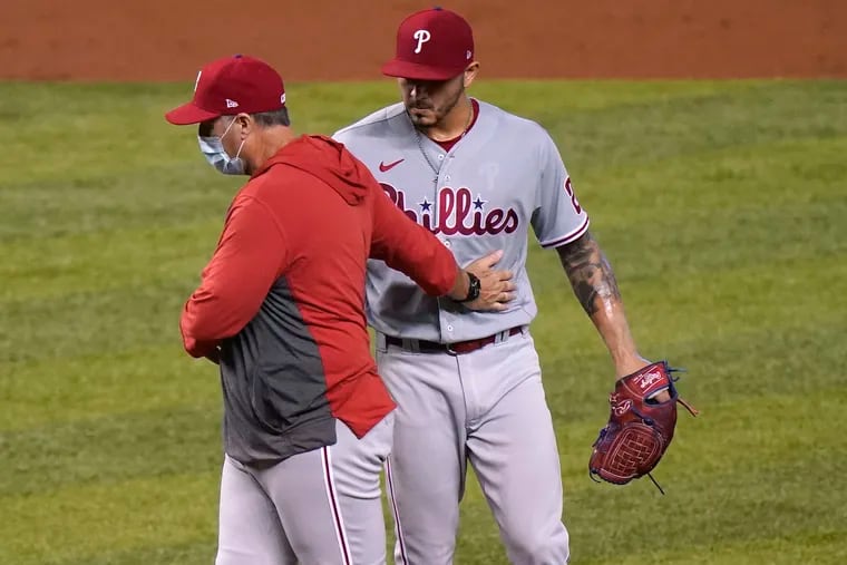 Phillies pitching coach Bryan Price talks with starter Vince Velasquez as the base are loaded during the second inning.