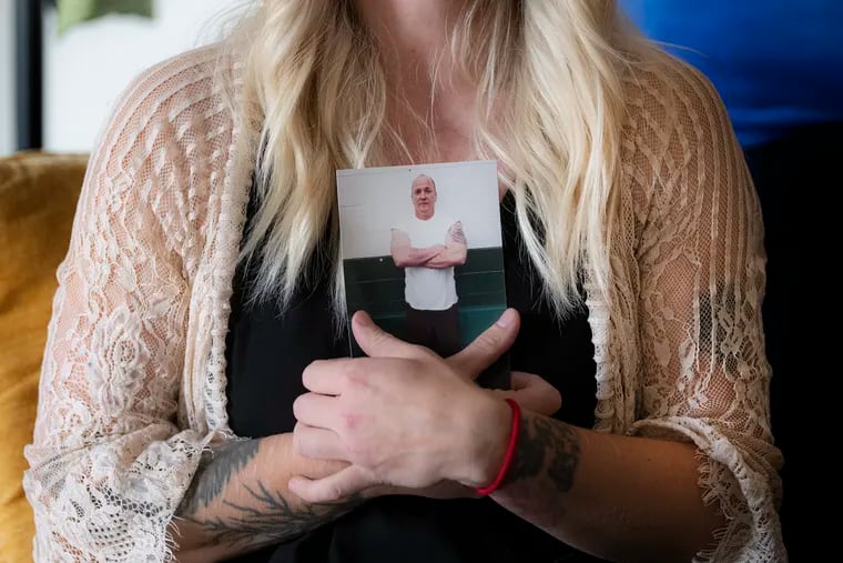 Sadie Smith Burnell holds a photo of her late father, Richard Allen Smith, at her home in Ridley Park. His death was particularly tragic, she said, because he was taking steps to correct past mistakes.