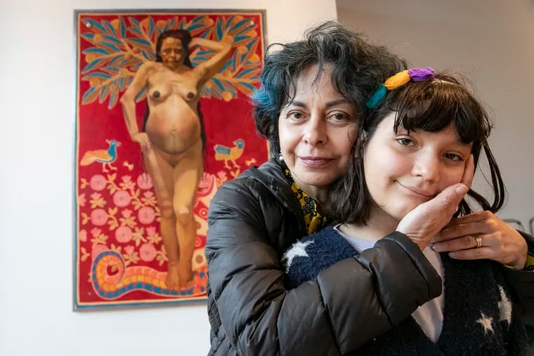 Artist Kukuli Velarde poses for a portrait in front of her artwork with her daughter, Vida Velarde-Herren,10, inside the new location for Clay Studio in the Olde Kensington section of Philadelphia on Wednesday, April 6, 2022. The grand opening of the new studio, which was formerly in Old City for 50 years, will be this Saturday.
