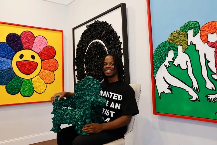 Balloon artist Brian Ward with his art at his North Philadelphia home on Monday, August 19, 2024. The piece at right is a re-creation of a work by Evelyne Axell, who has inspired him to use bolder colors.