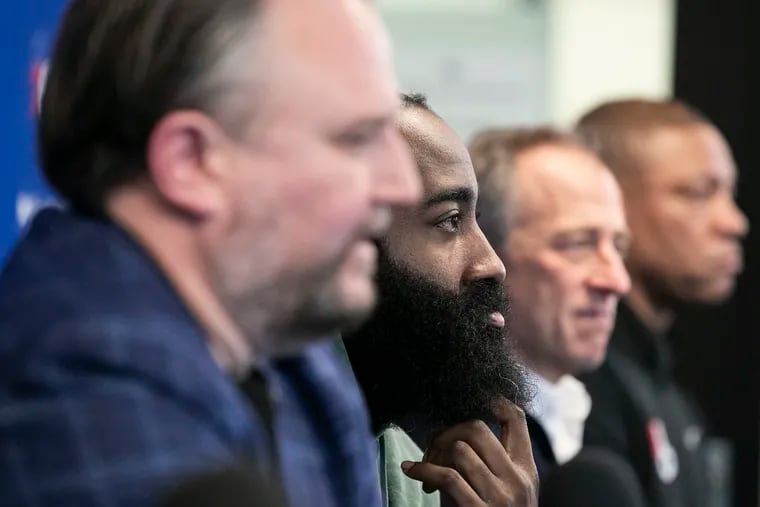 James Harden sits between Daryl Morey (left), owner Josh Harris, and former coach Doc Rivers (far right) during a press conference on Feb. 15, 2022.