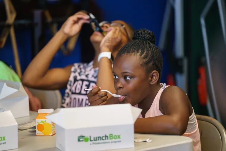 Sahiyah Cooper, 8, front right, Egypt Savage, 11, back left, during a lunch provided by Philabundance at the Police Athletic League, in South Philadelphia, July 10, 2019. Philabundance is tripling the number of meals it's providing this summer for low-income children. Summer is the hungriest time of year for Philly kids, since they're not eating breakfast and lunch in school.