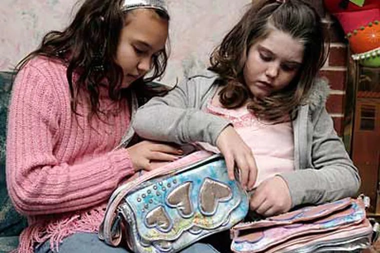 Daisy Daly, 9, (left) and Cartier Thomas, 7, with their Rebelle Friendship bags at Cartier's home. (Akira Suwa / Staff Photographer)