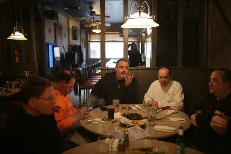 Joe Julia, center, talks with his friends during their weekly dinner at the Messina Club .