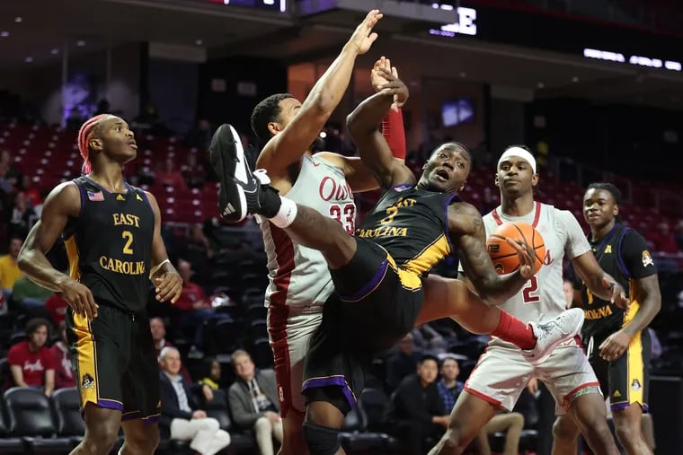 Sam Hofman, 2nd from left, of Temple fouls R.J. Felton of East Carolina after he went up for a shot during the 2nd half at the Liacouras Center on Jan. 10, 2024.