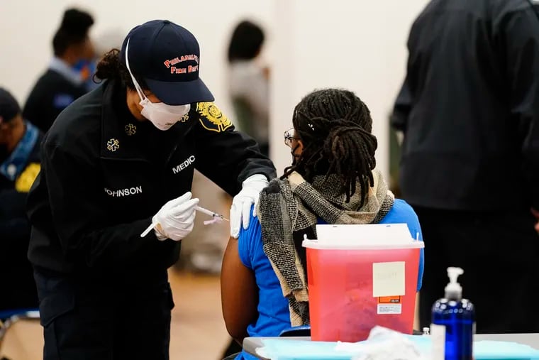 A member of the Philadelphia Fire Department administers a COVID-19 vaccine to a person at a vaccination site in Philadelphia, Monday, March 29, 2021.