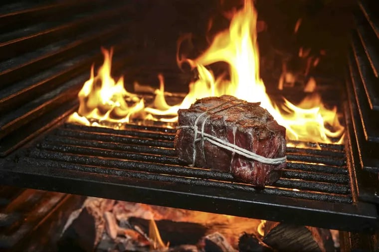 A bone-in tenderloin roasts over the live fire at Cadence, a modern American BYOB on West Girard Avenue.