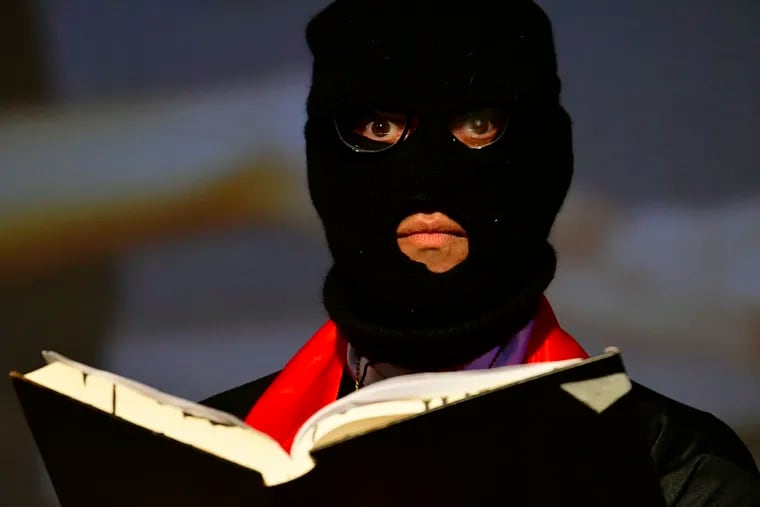 Wearing a ski mask, Ernest Hemmings performs as Father Business during the premier at the Cannonball Festival of “The Holy Church of Bezos.”