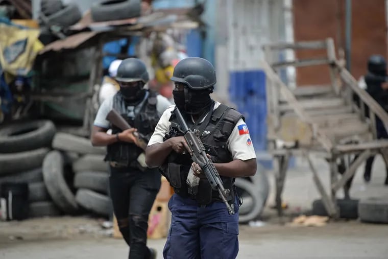 Police officers patrol a neighborhood amid gang-related violence in downtown Port-au-Prince, the Haitian capital, in April.
