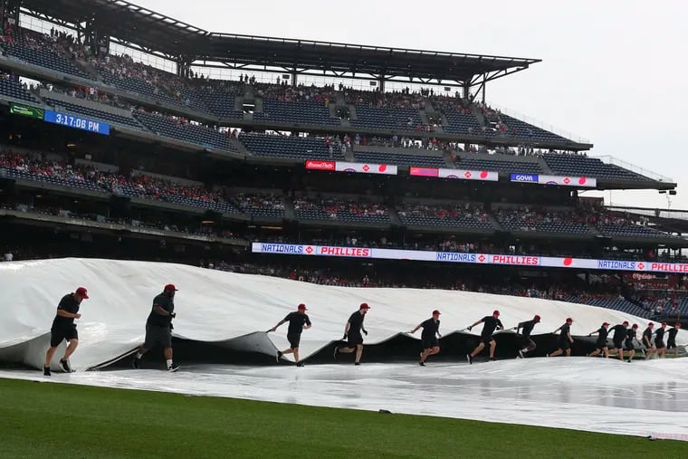 The field crew removes the tarp following a rain delay during a game on July 2 at Citizens Bank Park.