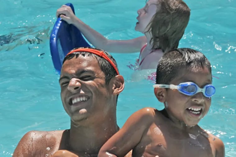 Camp counselor Sean Brazil, 17, enjoys the pool with camper Chase Racz, 6. The camp has nearly 1,000 children each summer.  (April Saul / Staff Photographer)
