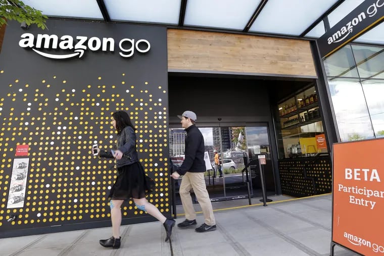 People walk past an Amazon Go store in Seattle on Monday, Jan. 22, 2018.