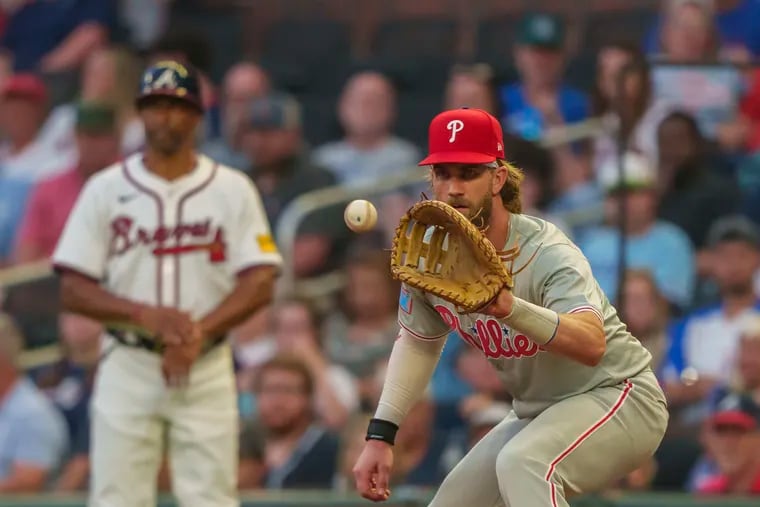 Phillies first baseman Bryce Harper catches a throw from Alec Bohm to retire Atlanta's Whit Merrifield  in the third inning Wednesday.