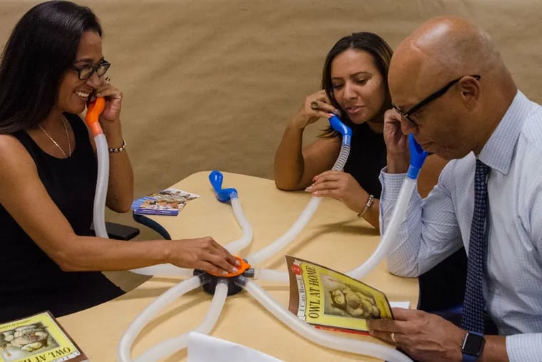 Superintendent Hite (right) reads a passage from Owl At Home through a new telephone tool that's part of a first grade classroom at Stearne Elementary School. Behind him is Mecca Jackson, the new principal of Stearne, and on the left is Paula Sahm, one of the educational facitilies planners.