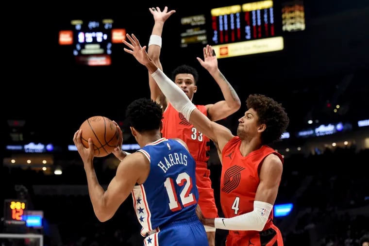 Sixers forward Tobias Harris looks to pass as the Trail Blazers' Toumani Camara (33) and Matisse Thybulle (4) defend on Monday in Portland.